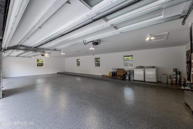 garage featuring independent washer and dryer and a garage door opener