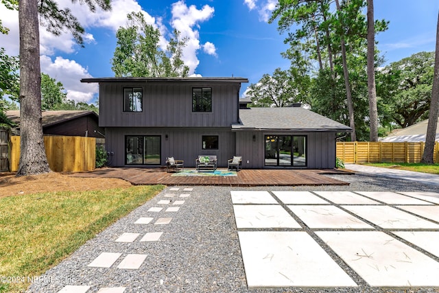 back of property with outdoor lounge area, a patio, and a deck