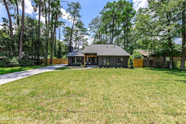 ranch-style home featuring a sunroom and a front lawn