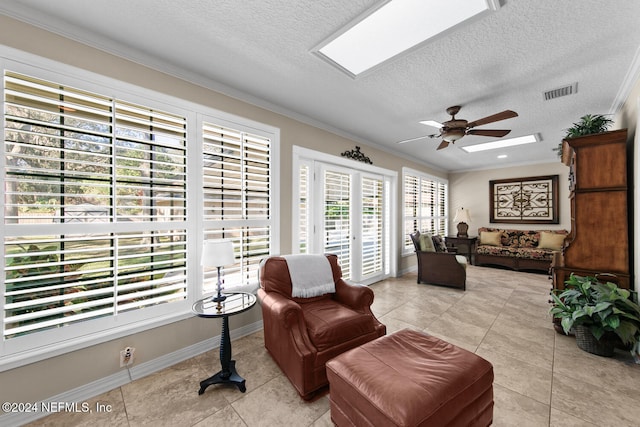 sitting room featuring a textured ceiling, ceiling fan, crown molding, and light tile patterned flooring