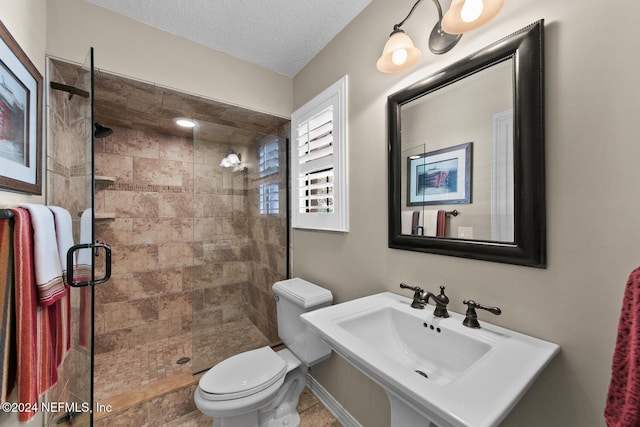 bathroom featuring sink, toilet, a textured ceiling, and walk in shower