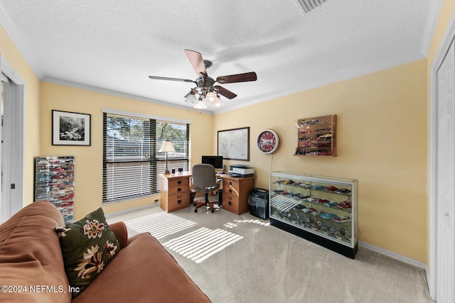 office space featuring light carpet, crown molding, ceiling fan, and a textured ceiling