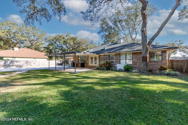 rear view of property with a patio and a lawn