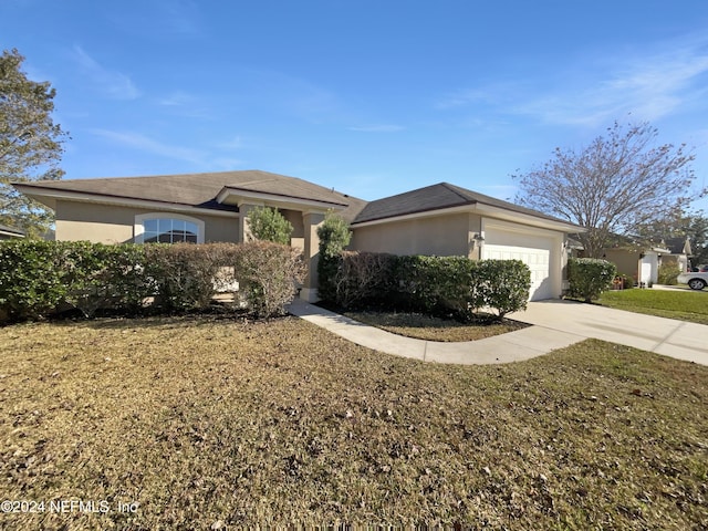 view of front of home with a front yard and a garage