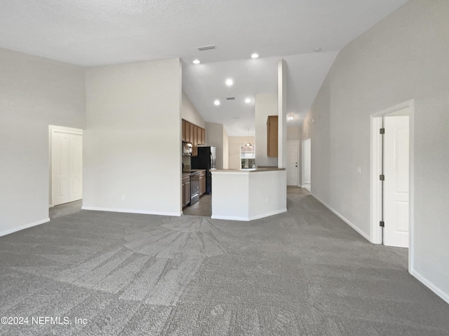 unfurnished living room featuring dark colored carpet and high vaulted ceiling