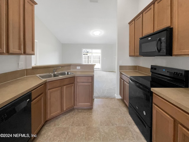 kitchen with light carpet, kitchen peninsula, sink, black appliances, and lofted ceiling