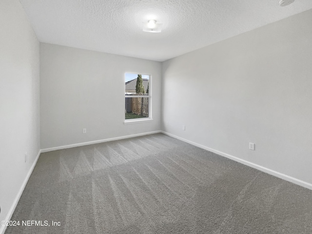 unfurnished room featuring carpet flooring and a textured ceiling