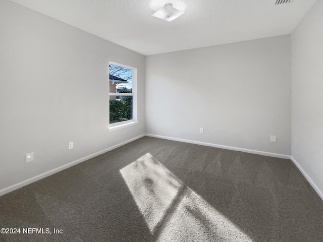 carpeted spare room featuring a textured ceiling