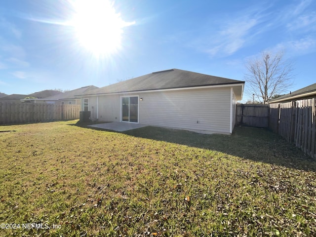 rear view of property with a lawn and a patio