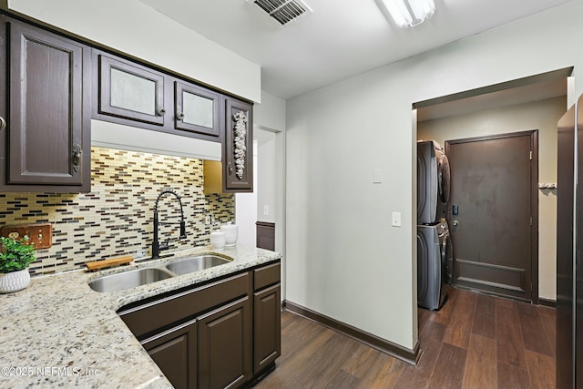 11657 Tanager Dr, Jacksonville, FL 32225 - kitchen featuring visible vents, backsplash, dark wood finished floors, stacked washing maching and dryer, and a sink