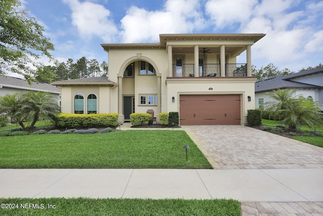 view of front facade with a balcony, a garage, and a front lawn