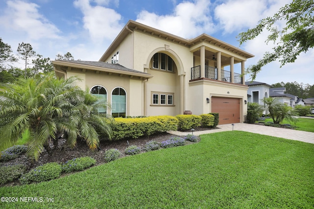 mediterranean / spanish house featuring a balcony, a front yard, and a garage