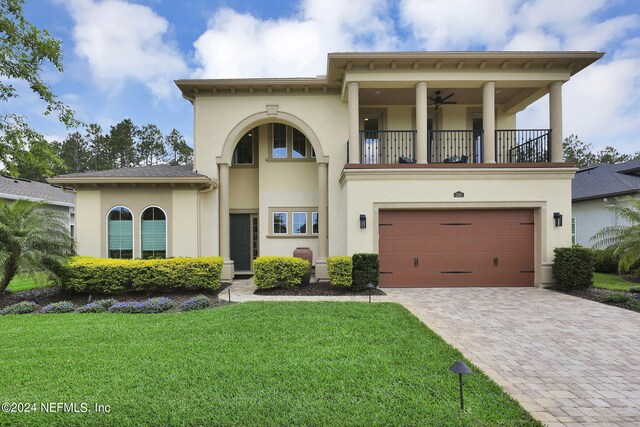 view of front of home with a garage, a balcony, and a front lawn