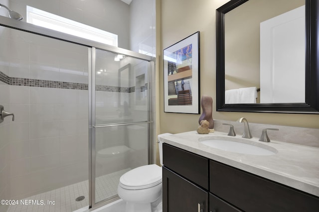 bathroom featuring vanity, an enclosed shower, and toilet