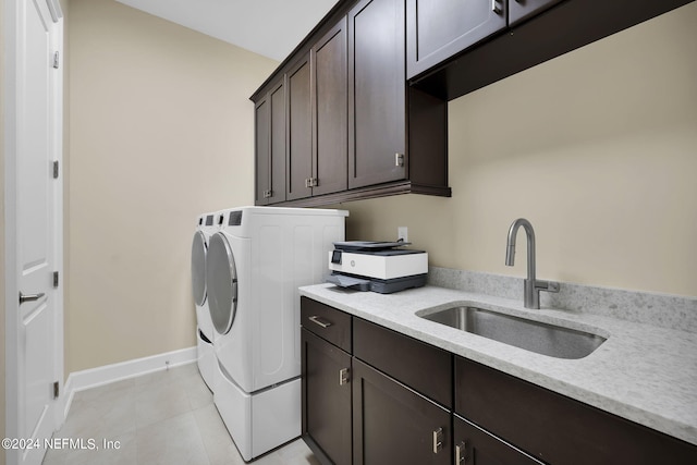 laundry room with cabinets, sink, light tile patterned flooring, and washer and dryer