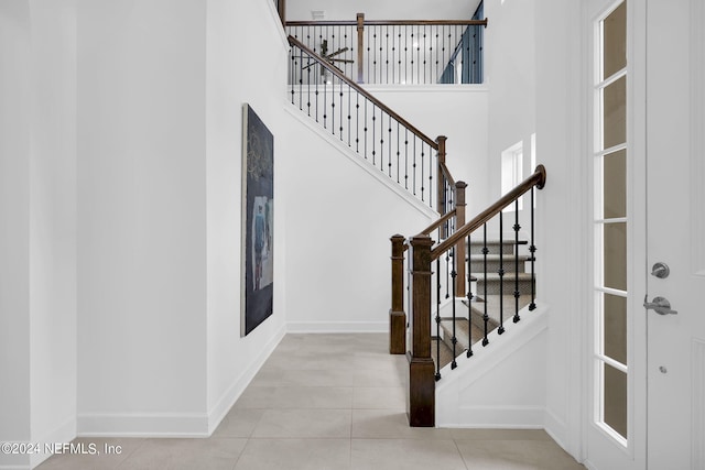 tiled entrance foyer featuring a towering ceiling