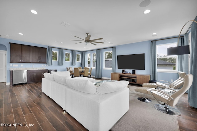 living room with ceiling fan and dark hardwood / wood-style flooring