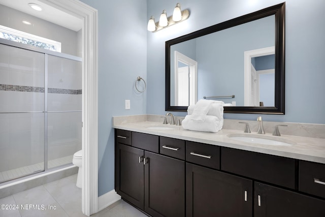 bathroom featuring tile patterned flooring, vanity, toilet, and walk in shower