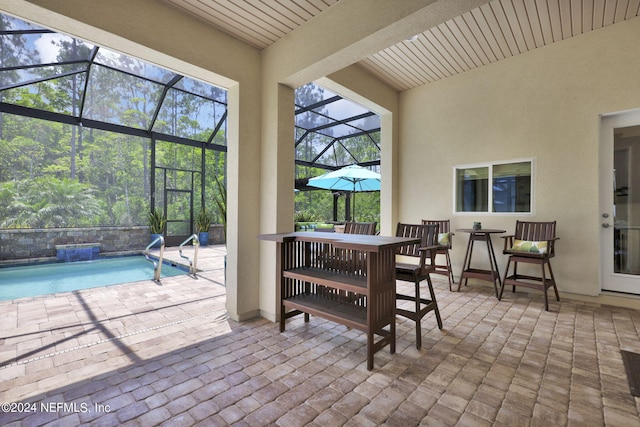 view of patio featuring a lanai