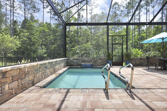 view of pool featuring pool water feature, a patio, and a lanai