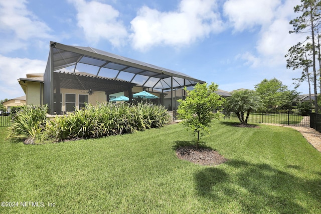 view of yard featuring a lanai and ceiling fan