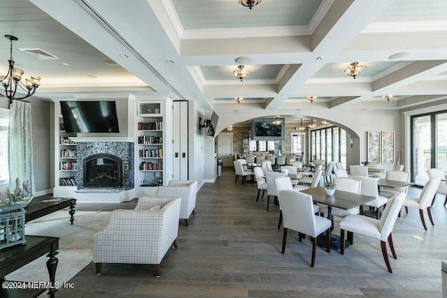 dining area with dark wood-type flooring, coffered ceiling, crown molding, a fireplace, and beamed ceiling