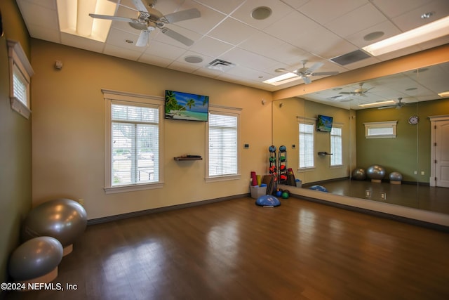 exercise room with a paneled ceiling and hardwood / wood-style flooring