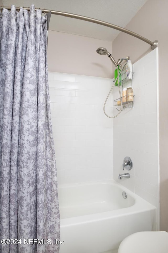 bathroom with shower / tub combo with curtain and toilet