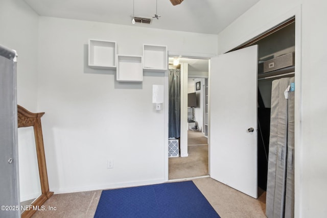 unfurnished bedroom featuring light colored carpet, a closet, and ceiling fan