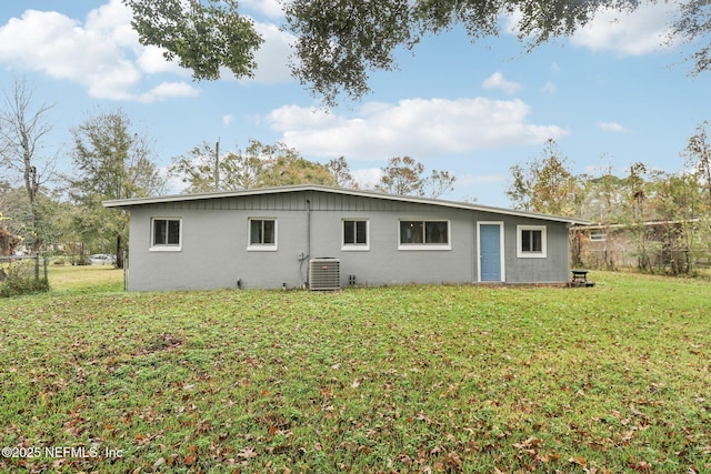 rear view of property with a lawn and central AC unit