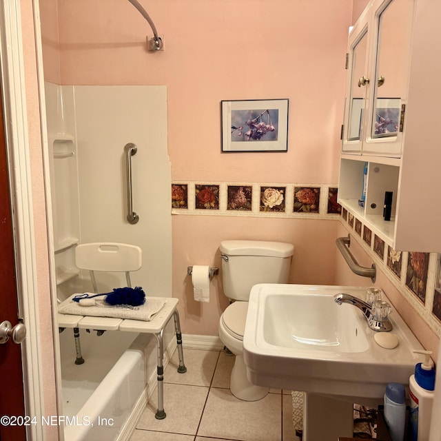 bathroom featuring tile patterned flooring, a bath, and toilet