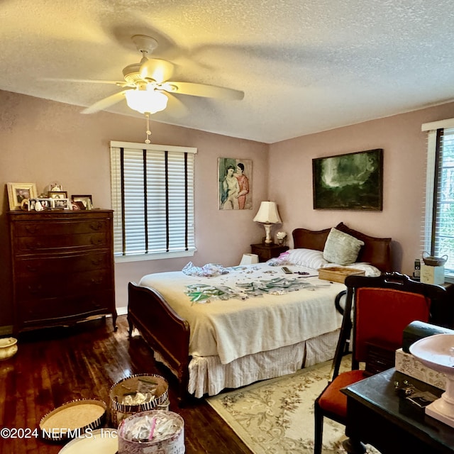 bedroom with ceiling fan, dark hardwood / wood-style flooring, and a textured ceiling