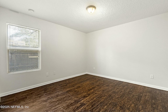 spare room with dark hardwood / wood-style flooring and a textured ceiling