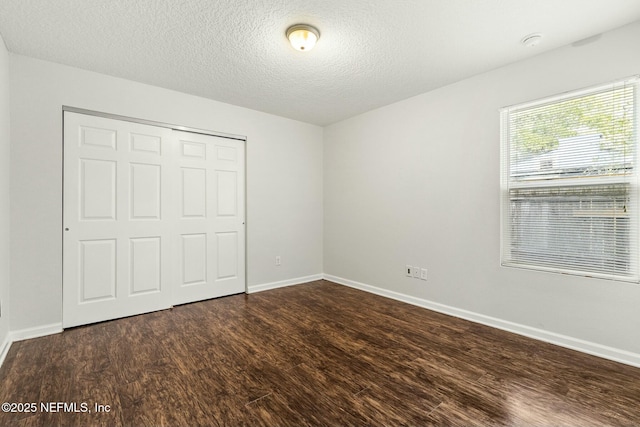 unfurnished bedroom featuring dark hardwood / wood-style floors, a closet, and a textured ceiling