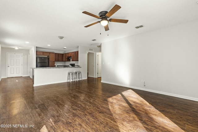 unfurnished living room with dark wood-type flooring and ceiling fan