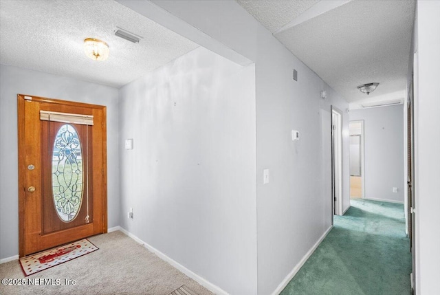 foyer entrance featuring carpet and a textured ceiling