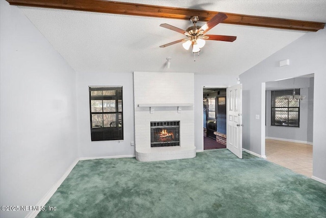 unfurnished living room featuring carpet, a brick fireplace, vaulted ceiling with beams, ceiling fan, and a textured ceiling