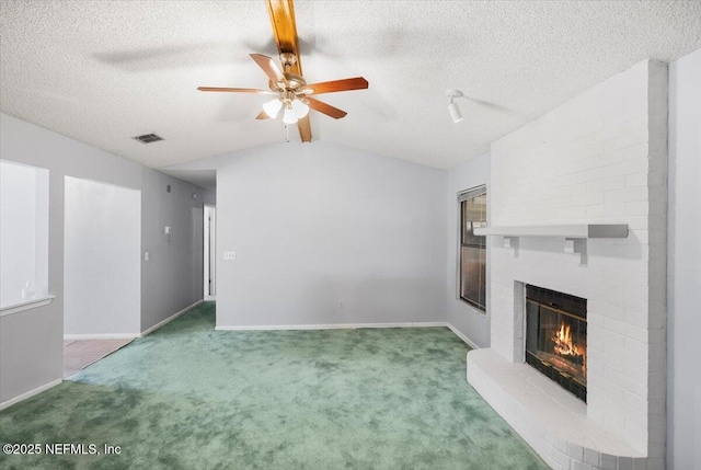 unfurnished living room with carpet flooring, ceiling fan, a fireplace, and vaulted ceiling