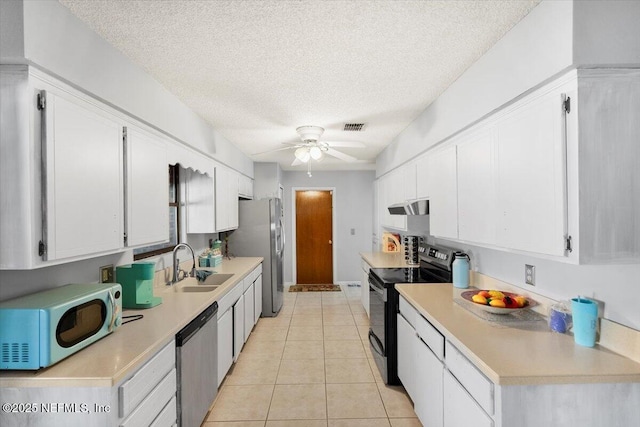 kitchen featuring sink, ceiling fan, light tile patterned floors, white cabinetry, and stainless steel appliances