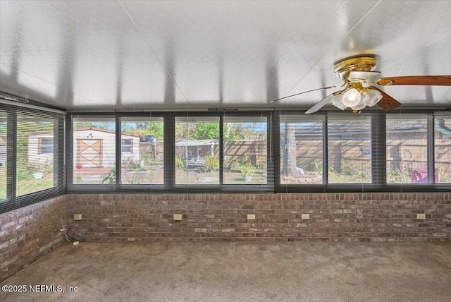 unfurnished sunroom with ceiling fan