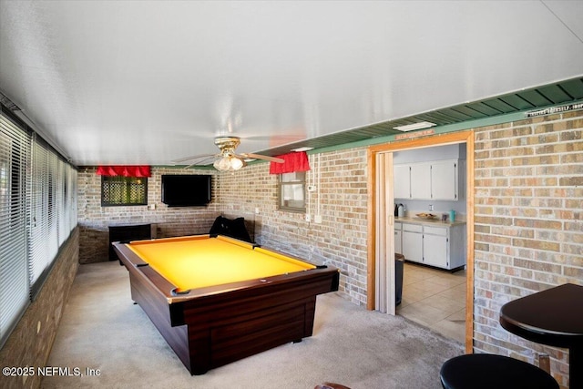 rec room with brick wall, light colored carpet, ceiling fan, and billiards