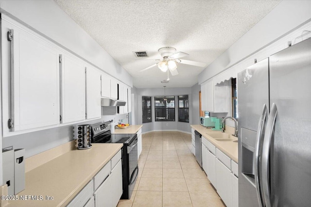 kitchen with white cabinets, sink, ceiling fan, light tile patterned floors, and appliances with stainless steel finishes