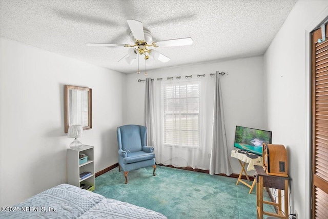 carpeted bedroom with ceiling fan and a textured ceiling