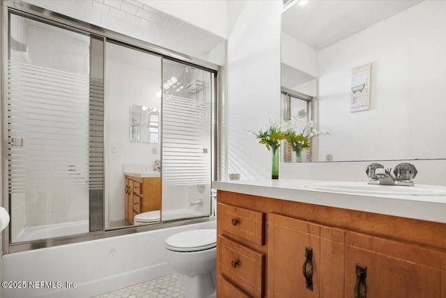 full bathroom featuring tile patterned flooring, toilet, vanity, and combined bath / shower with glass door