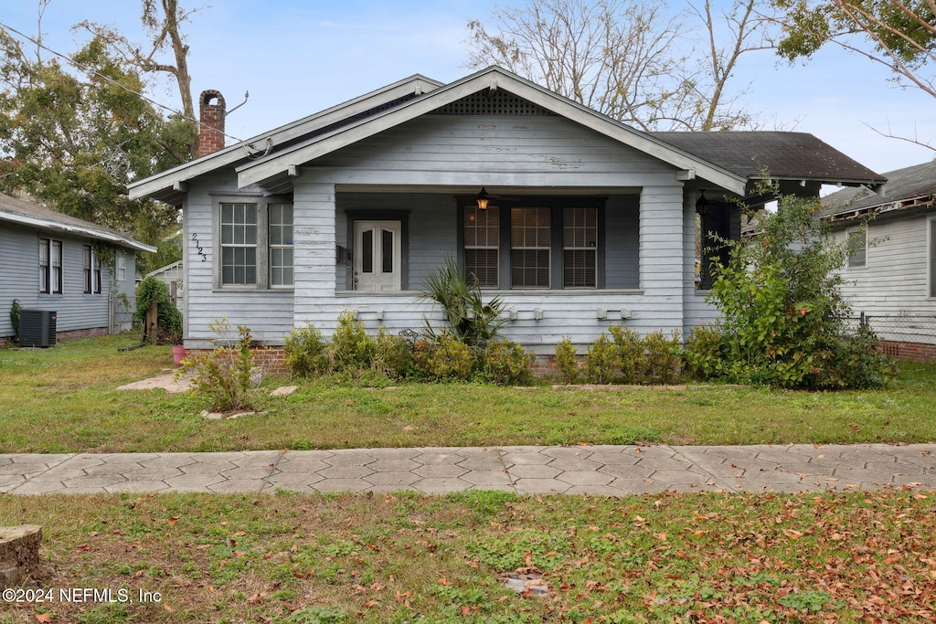 bungalow featuring central air condition unit and a front lawn