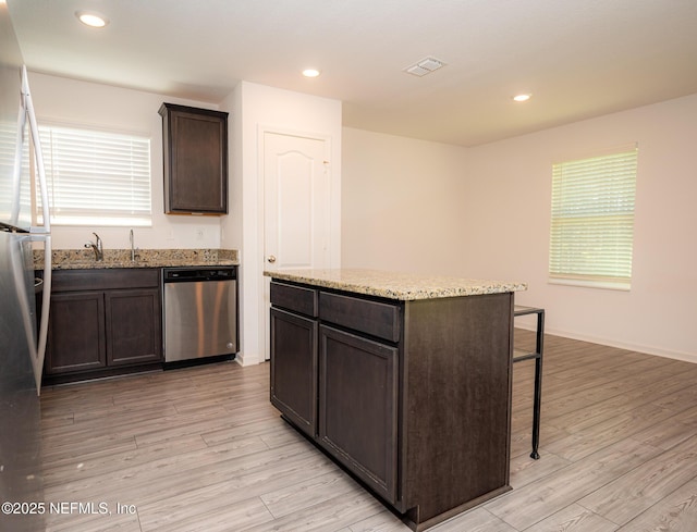 kitchen featuring a center island, sink, dark brown cabinets, light hardwood / wood-style floors, and stainless steel appliances