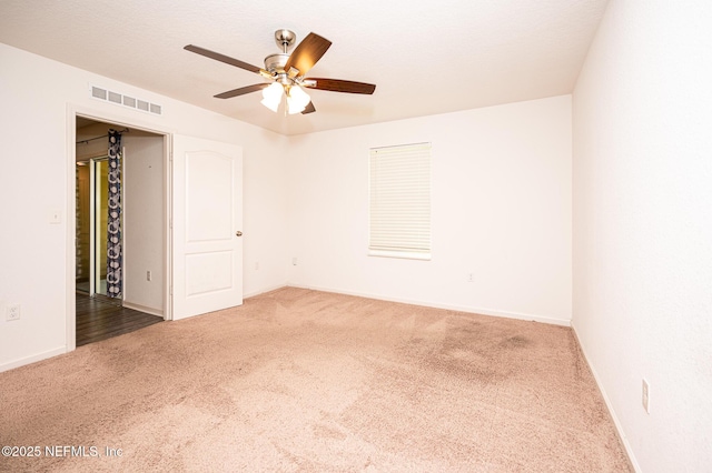 spare room with ceiling fan and carpet