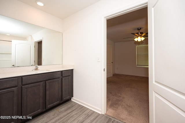 bathroom with hardwood / wood-style floors, vanity, and ceiling fan