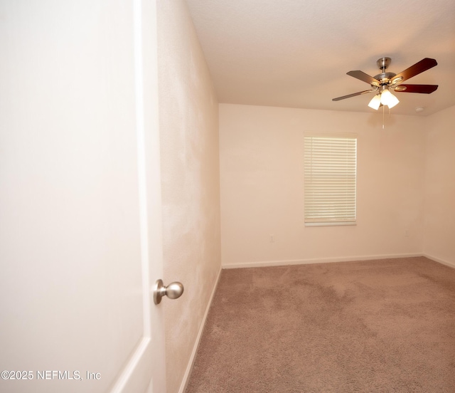 carpeted empty room featuring ceiling fan