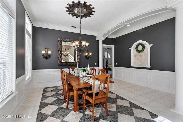 dining room with tile patterned flooring, a chandelier, decorative columns, and ornamental molding